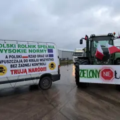 Ciężarówka i traktor z transparentami protestacyjnymi rolników, flagi Polski.