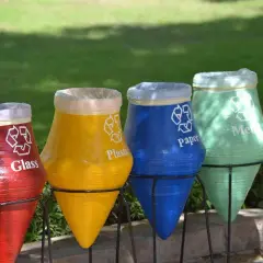 Kolorowe garnki do segregacji śmieci: czerwony na szkło, żółty na plastik, niebieski na papier, zielony na metal.