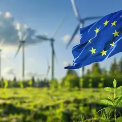 Flaga UE powiewa nad farmą wiatrową, symbolizując, czego dotyczy zielony ład: zrównoważony rozwój i czystą energię dla przyszłości.