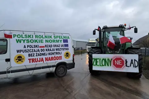 Ciężarówka i traktor z transparentami protestacyjnymi rolników, flagi Polski.