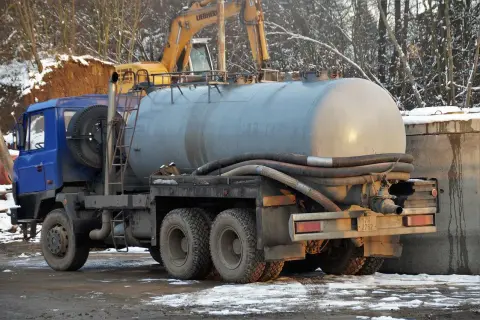 Ciężarówka z szambem czeka na rozładunek. Dowiedz się, ile kosztuje wywóz szamba do oczyszczalni.