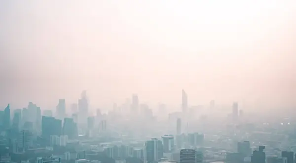 Widok miasta spowitego mgłą, która może być efektem różnych rodzajów smogu.