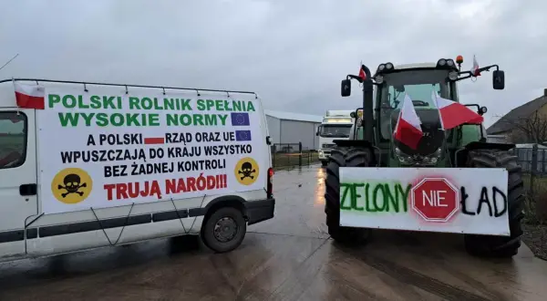 Ciężarówka i traktor z transparentami protestacyjnymi rolników, flagi Polski.