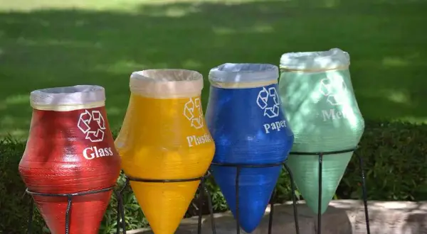 Kolorowe garnki do segregacji śmieci: czerwony na szkło, żółty na plastik, niebieski na papier, zielony na metal.