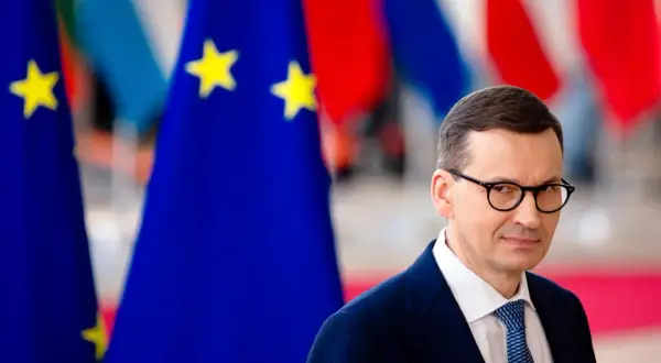 Mateusz Morawiecki w okularach, na tle flag UE. Czy to moment, kiedy Morawiecki podpisał zielony ład?