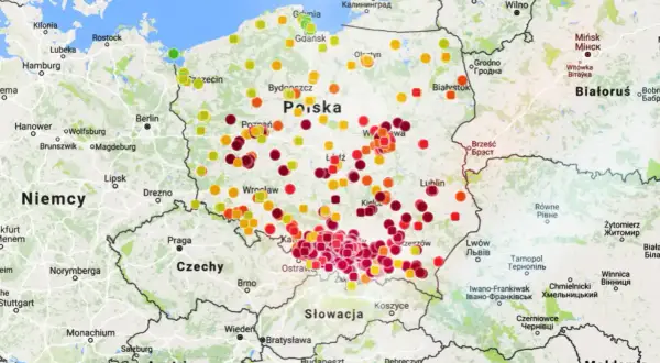 Mapa Polski z kropkami w różnych kolorach oznaczającymi poziom zanieczyszczenia powietrza.