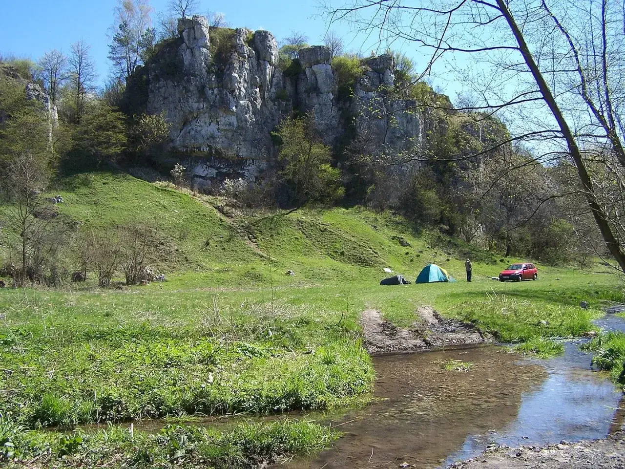 Malowniczy rezerwat przyrody Dolina Kluczwody z namiotami i czerwonym samochodem, idealne miejsce na biwak.