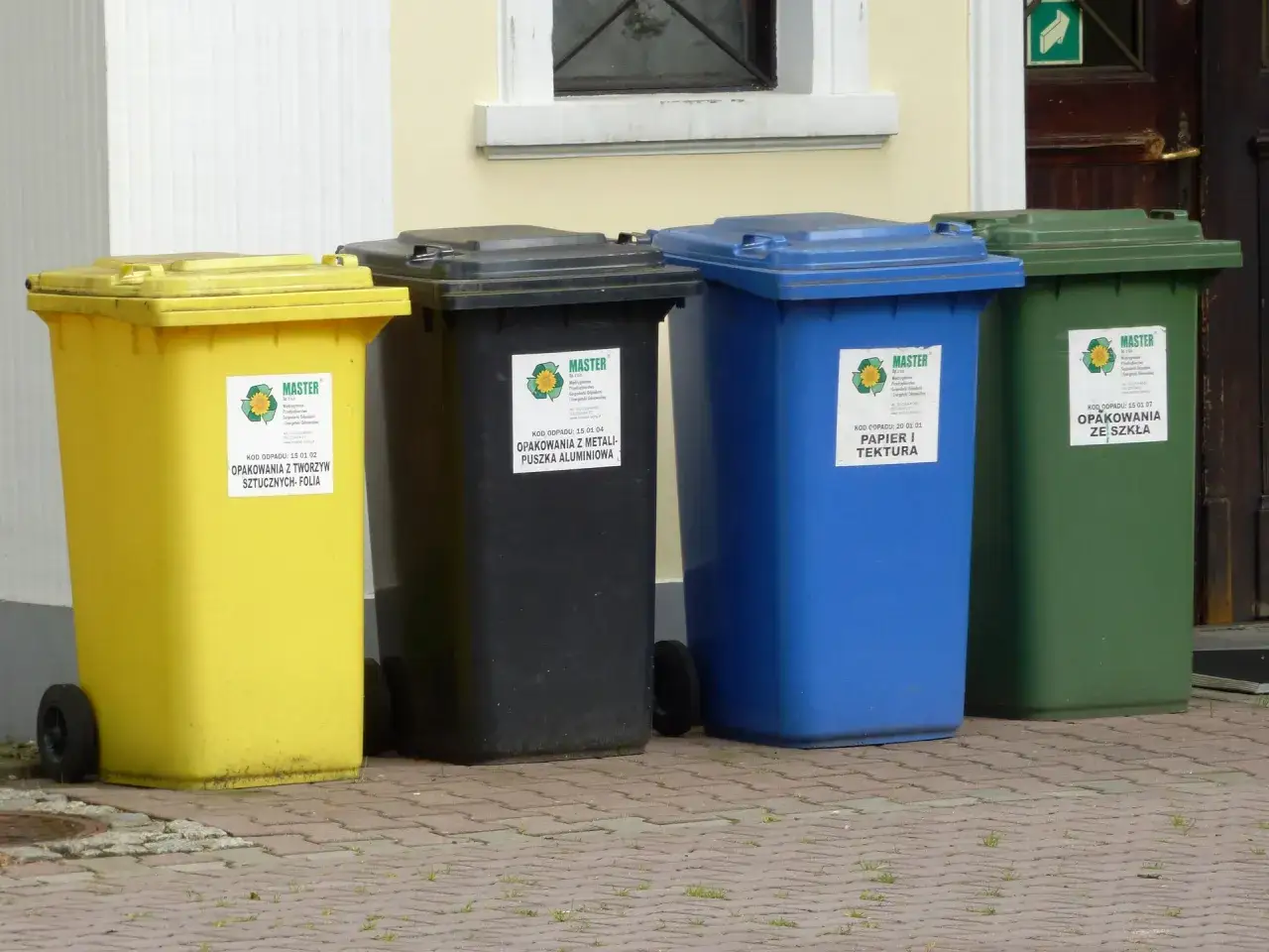 Cztery kosze do segregacji: ż&oacute;łty (plastik), czarny (metal), niebieski (papier) i zielony (szkło). Czy śmieci do segregacji należy myć?