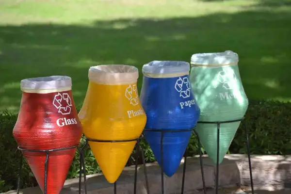 Kolorowe garnki do segregacji śmieci: czerwony na szkło, żółty na plastik, niebieski na papier, zielony na metal.